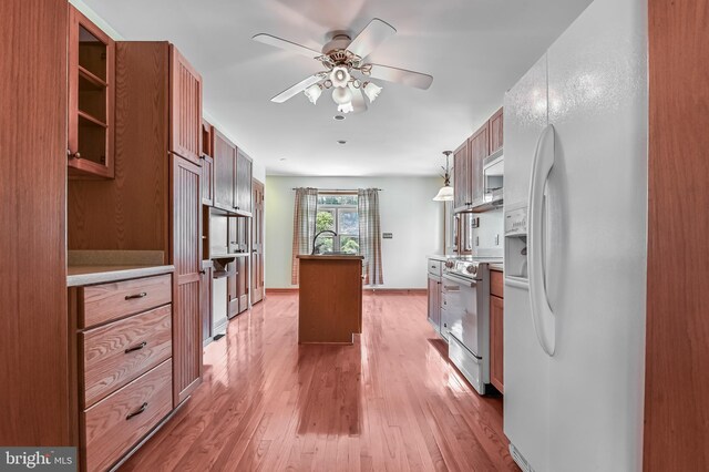 8283 Choptank Rd, Pasadena, MD 21122 - kitchen featuring white appliances, a center island, ceiling fan, brown cabinets, and light wood-style floors