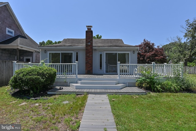 8283 Choptank Rd, Pasadena, MD 21122 - rear view of house featuring a chimney, a lawn, a wooden deck, and stucco siding