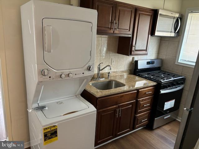 5755 E Capitol St SE, Washington, DC 20019 - laundry area with stacked washing machine and dryer and dark wood finished floors