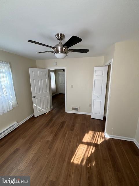 5755 E Capitol St SE, Washington, DC 20019 - unfurnished bedroom featuring wood finished floors, baseboard heating, and a ceiling fan