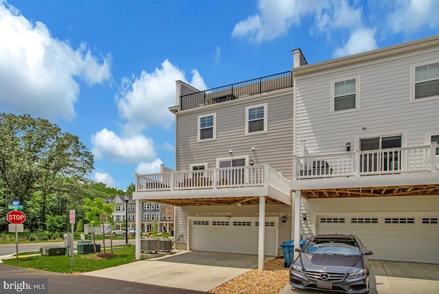 113 Treblis Way, Annapolis, MD 21403 - rear view of house with a garage, concrete driveway, a balcony, and a chimney