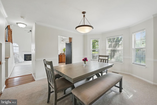 13297 Osage Dr, Woodbridge, VA 22193 - dining area featuring light carpet, crown molding, a glass covered fireplace, and ceiling fan