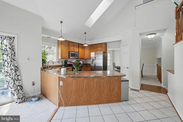 13297 Osage Dr, Woodbridge, VA 22193 - kitchen featuring appliances with stainless steel finishes, a peninsula, a skylight, dark countertops, and brown cabinetry