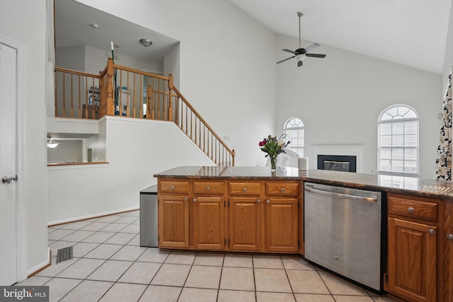13297 Osage Dr, Woodbridge, VA 22193 - kitchen featuring stainless steel dishwasher, a ceiling fan, high vaulted ceiling, a glass covered fireplace, and light tile patterned floors