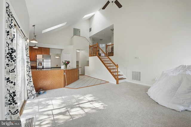 13297 Osage Dr, Woodbridge, VA 22193 - living area featuring ceiling fan, light colored carpet, high vaulted ceiling, stairs, and a skylight