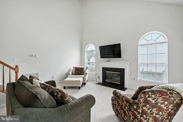 13297 Osage Dr, Woodbridge, VA 22193 - living room with carpet flooring, a fireplace with flush hearth, stairway, and a towering ceiling