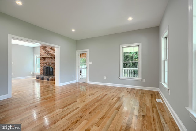 10905 Powers Ave, Cockeysville, MD 21030 - unfurnished living room featuring light wood-style floors, a brick fireplace, and recessed lighting