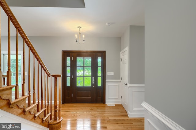10905 Powers Ave, Cockeysville, MD 21030 - foyer entrance with a chandelier, light wood finished floors, stairway, a wainscoted wall, and a decorative wall