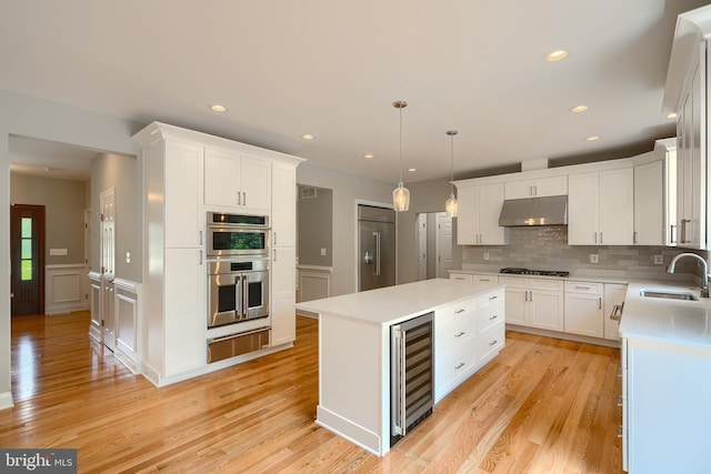 10905 Powers Ave, Cockeysville, MD 21030 - kitchen with stainless steel appliances, under cabinet range hood, a warming drawer, wine cooler, and a kitchen island