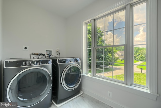 10905 Powers Ave, Cockeysville, MD 21030 - laundry room featuring separate washer and dryer, marble look tiles, and healthy amount of natural light