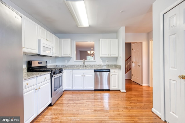 577 Francis Nicholson Way, Annapolis, MD 21401 - kitchen featuring appliances with stainless steel finishes, light wood-style floors, white cabinets, light stone countertops, and a chandelier