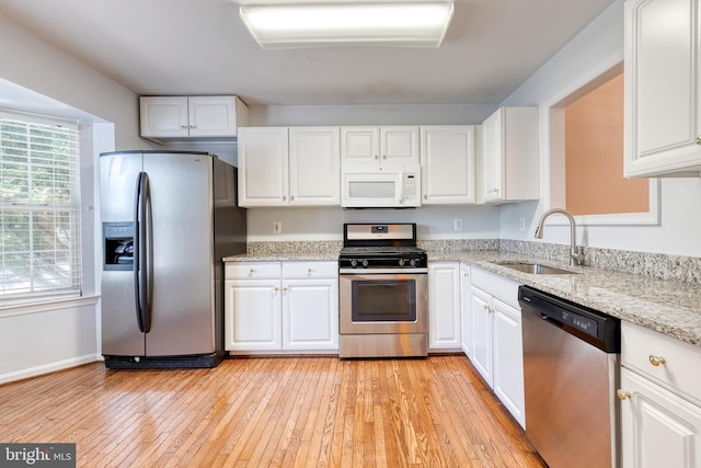 577 Francis Nicholson Way, Annapolis, MD 21401 - kitchen with stainless steel appliances, white cabinetry, light wood-style floors, and light stone counters