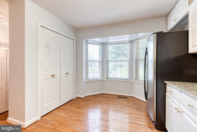 577 Francis Nicholson Way, Annapolis, MD 21401 - kitchen featuring freestanding refrigerator, light wood-type flooring, white cabinetry, and light stone countertops