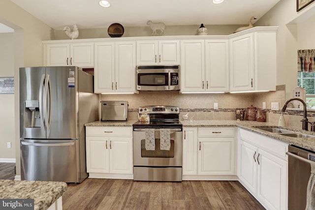 1283 Yarmouth Ln, New Cumberland, PA 17070 - kitchen with appliances with stainless steel finishes, light wood-style floors, white cabinets, light stone countertops, and backsplash