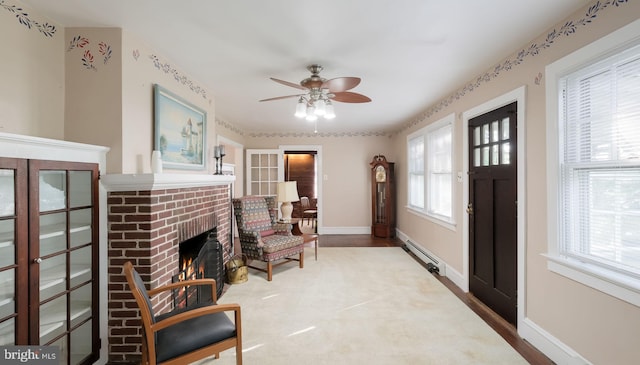 1081 Wynnwood Rd, Abington, PA 19001 - sitting room with a baseboard radiator, a ceiling fan, a brick fireplace, and wood finished floors