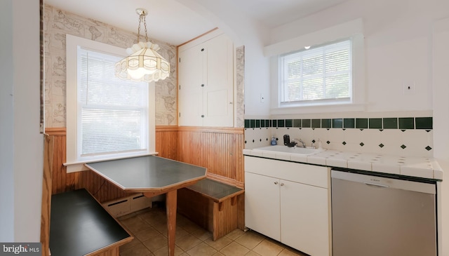 1081 Wynnwood Rd, Abington, PA 19001 - kitchen featuring stainless steel dishwasher, tile countertops, wainscoting, a chandelier, and white cabinets