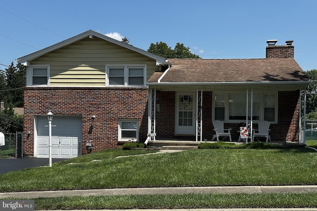 2423 Wharton Rd, York, PA 17402 - view of front of house featuring brick siding, a garage, driveway, and a chimney