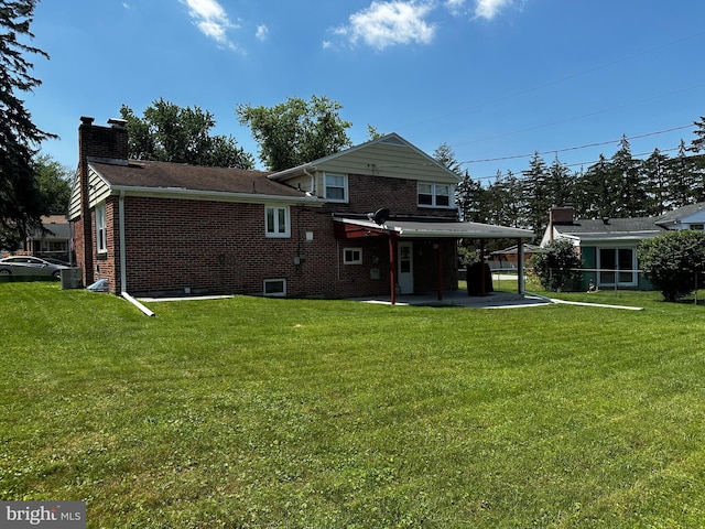 2423 Wharton Rd, York, PA 17402 - rear view of property with brick siding, a chimney, and a lawn