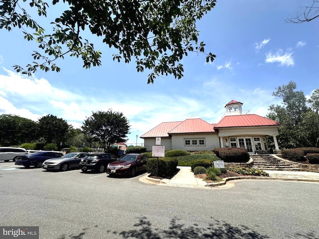 18815 Sparkling Water Dr Unit 4-O, Germantown, MD 20874 - view of front of property featuring uncovered parking, a metal roof, stucco siding, and french doors
