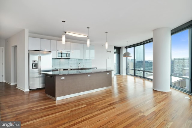 2101 Market St Unit 1902, Philadelphia, PA 19103 - kitchen featuring stainless steel appliances, healthy amount of natural light, light wood-style floors, and expansive windows