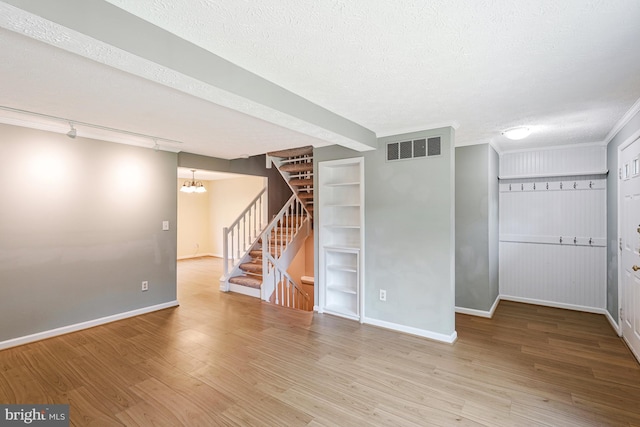 1668 Barnstead Dr, Reston, VA 20194 - empty room featuring stairway, wood finished floors, a textured ceiling, a chandelier, and track lighting