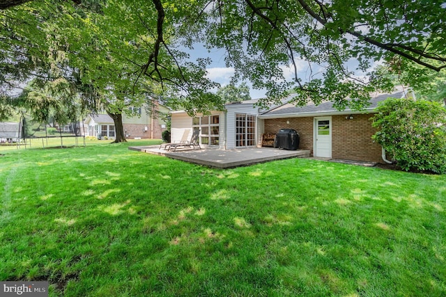 114 Brookside Ave, Hershey, PA 17033 - back of house with a trampoline, brick siding, a lawn, and a deck