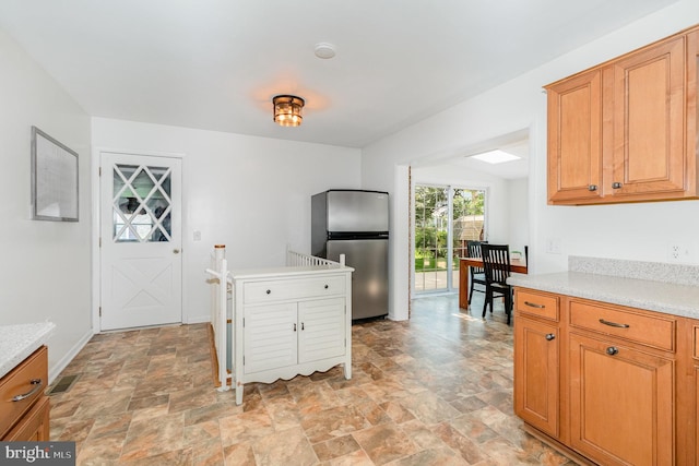 114 Brookside Ave, Hershey, PA 17033 - kitchen with freestanding refrigerator, stone finish floors, light countertops, and brown cabinets