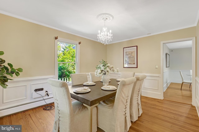 1012 Grant St, Herndon, VA 20170 - dining room featuring a baseboard heating unit, a chandelier, light wood-style flooring, crown molding, and a wainscoted wall