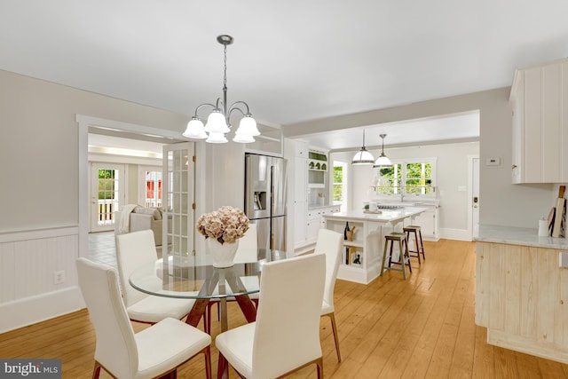 1012 Grant St, Herndon, VA 20170 - dining space with light wood-type flooring, a chandelier, and a wainscoted wall