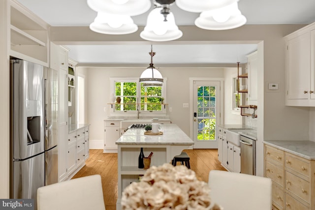 1012 Grant St, Herndon, VA 20170 - kitchen with appliances with stainless steel finishes, open shelves, light wood finished floors, white cabinetry, and a center island