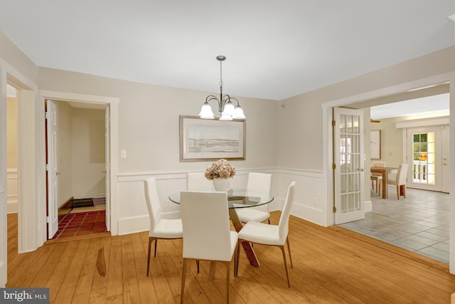 1012 Grant St, Herndon, VA 20170 - dining space featuring a chandelier, light wood-style flooring, and wainscoting