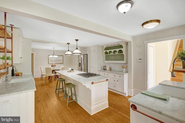 1012 Grant St, Herndon, VA 20170 - kitchen featuring stainless steel appliances, white cabinets, light wood-style floors, and a breakfast bar area