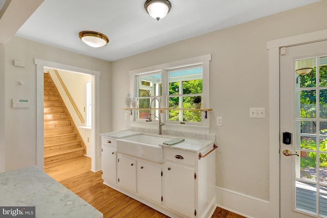 1012 Grant St, Herndon, VA 20170 - kitchen featuring light wood-style floors, plenty of natural light, white cabinetry, and light stone counters