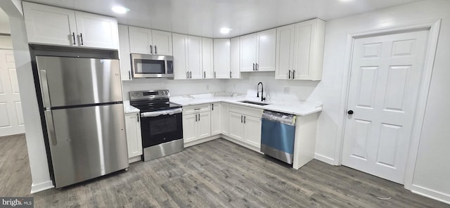 4211 Torque St, Capitol Heights, MD 20743 - kitchen with stainless steel appliances, recessed lighting, wood finished floors, white cabinetry, and light countertops