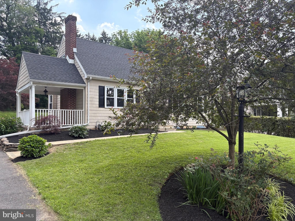 424 N Rolling Rd, Springfield, PA 19064 - view of front of property featuring covered porch, a shingled roof, a front lawn, and a chimney