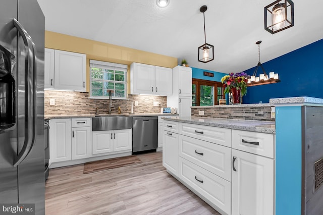 47 Sheridan Rd, Arnold, MD 21012 - kitchen featuring appliances with stainless steel finishes, decorative backsplash, decorative light fixtures, white cabinets, and vaulted ceiling