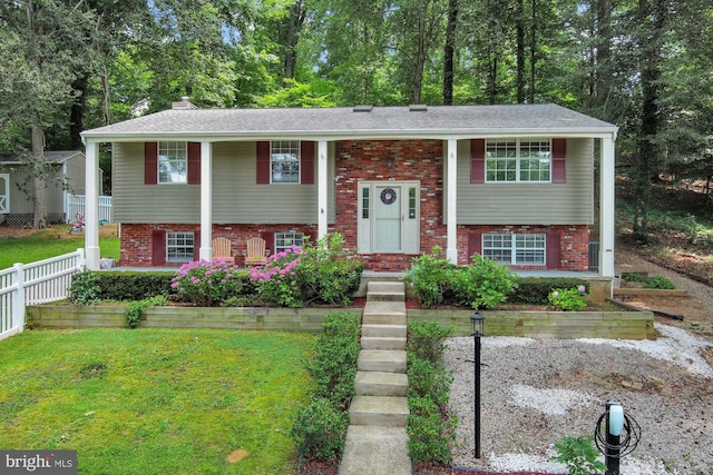 47 Sheridan Rd, Arnold, MD 21012 - raised ranch featuring brick siding, covered porch, a chimney, and view of scattered trees
