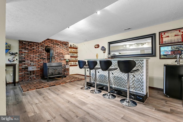 47 Sheridan Rd, Arnold, MD 21012 - bar area featuring wood finished floors, a textured ceiling, and a wood stove