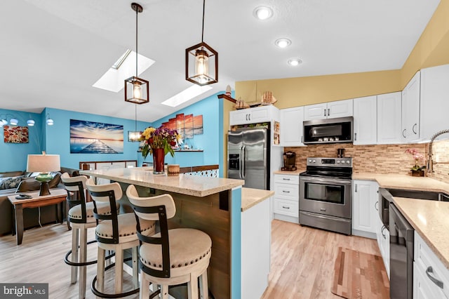 47 Sheridan Rd, Arnold, MD 21012 - kitchen featuring stainless steel appliances, a skylight, backsplash, light wood-style flooring, and light stone countertops