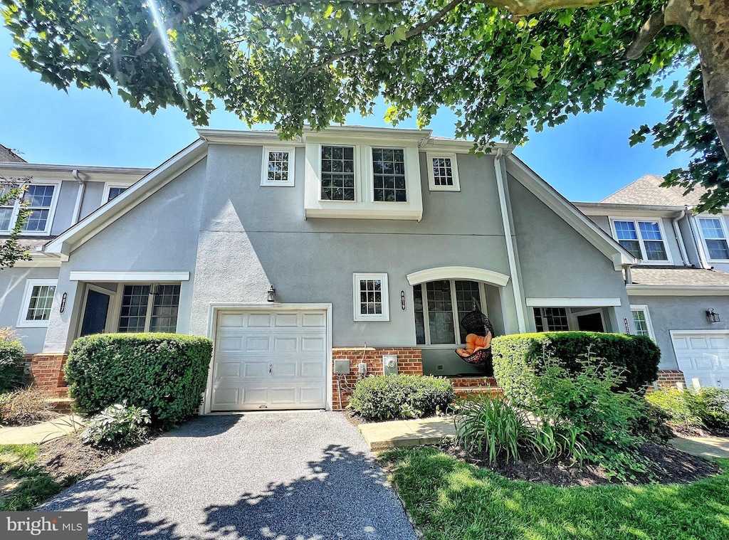 8819 Howard Frst Unit 8819, Baltimore, MD 21208 - view of front of property featuring driveway, brick siding, stucco siding, and a garage