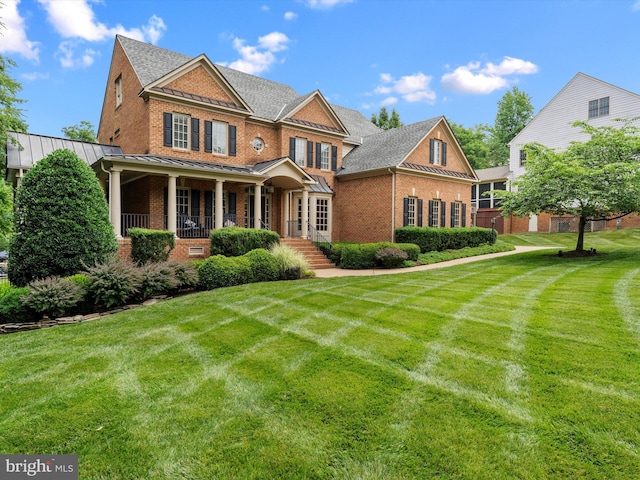 13412 Ellerton Ct, Midlothian, VA 23113 - colonial inspired home featuring brick siding, a standing seam roof, a front lawn, and a porch