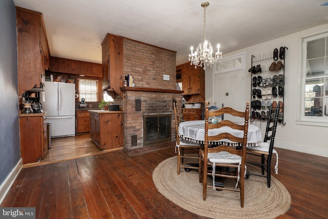 5378 Main St, Stephens City, VA 22655 - dining room with wood-type flooring, a chandelier, and a brick fireplace