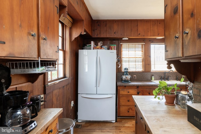 5378 Main St, Stephens City, VA 22655 - kitchen with freestanding refrigerator, brown cabinets, wooden walls, light wood finished floors, and butcher block countertops