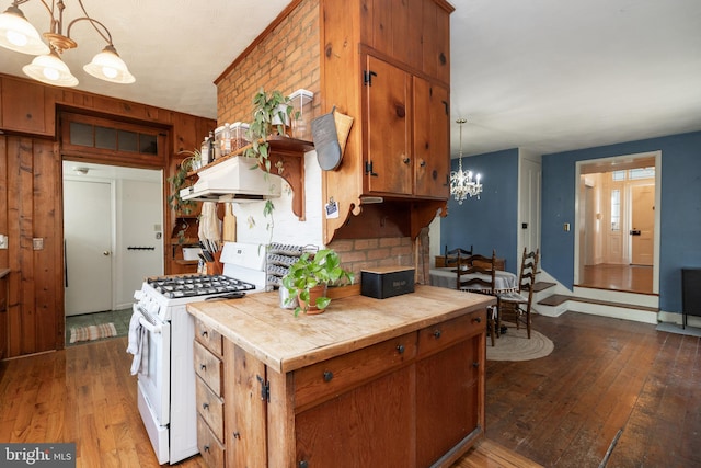 5378 Main St, Stephens City, VA 22655 - kitchen with white gas range, ventilation hood, a chandelier, hardwood / wood-style flooring, and brown cabinets