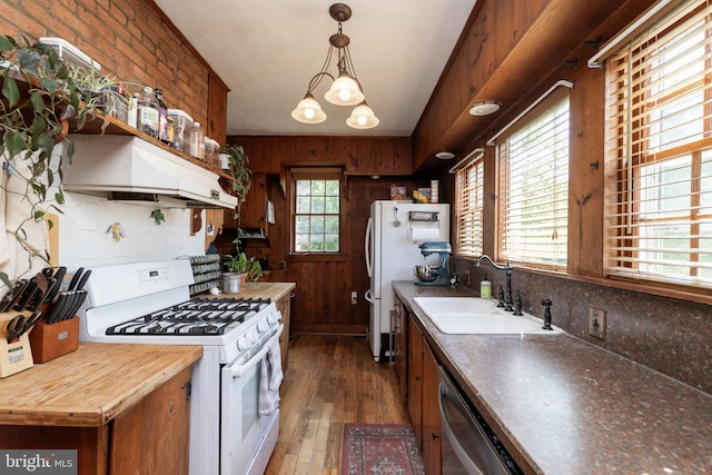 5378 Main St, Stephens City, VA 22655 - kitchen featuring white appliances, range hood, hardwood / wood-style floors, wooden walls, and decorative light fixtures