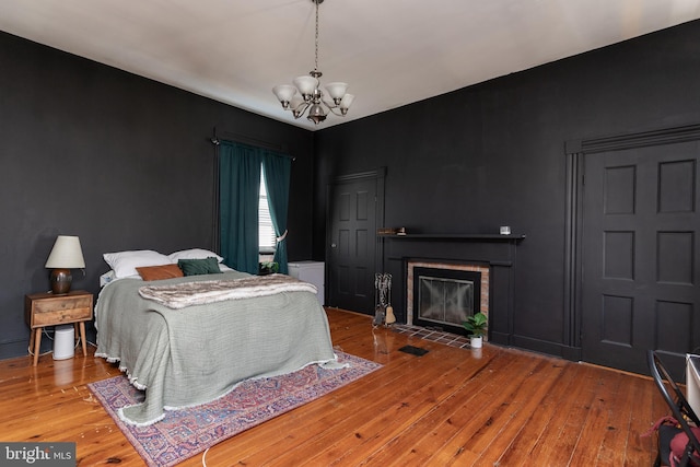 5378 Main St, Stephens City, VA 22655 - bedroom with a chandelier, hardwood / wood-style floors, and a fireplace