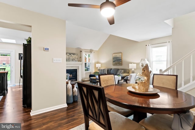6111 Summit Pointe Dr, Harrisburg, PA 17111 - dining space featuring a ceiling fan, dark wood-style floors, a glass covered fireplace, vaulted ceiling, and stairway