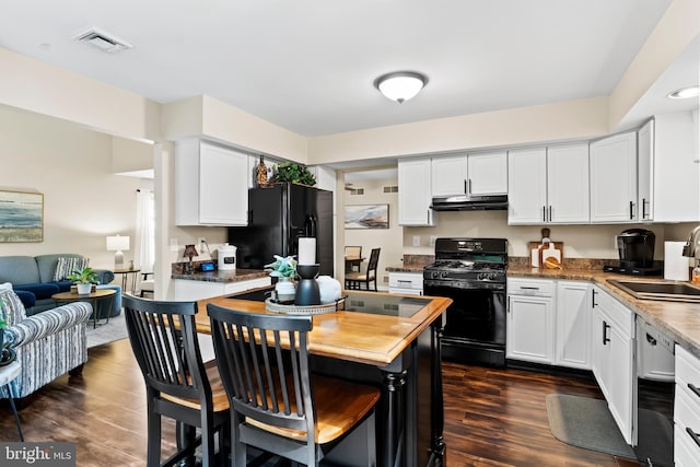 6111 Summit Pointe Dr, Harrisburg, PA 17111 - kitchen featuring black appliances, under cabinet range hood, dark wood finished floors, and white cabinets