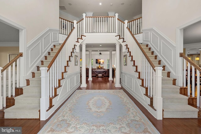 4400 Palomino Xing, Upper Marlboro, MD 20772 - staircase featuring ornamental molding, ornate columns, wood finished floors, a decorative wall, and a towering ceiling