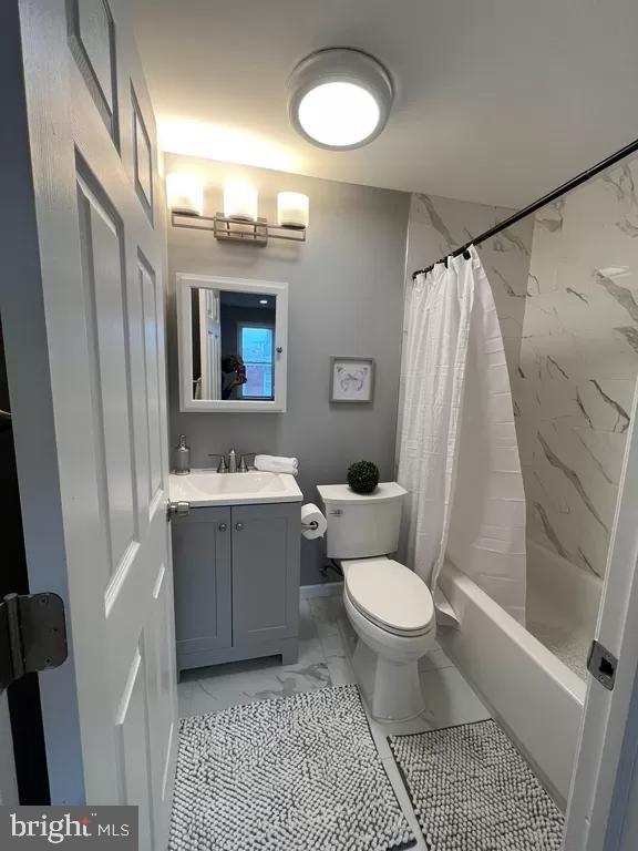 2057 N Franklin St, Philadelphia, PA 19122 - full bath featuring marble look tiles, vanity, and shower / tub combo with curtain